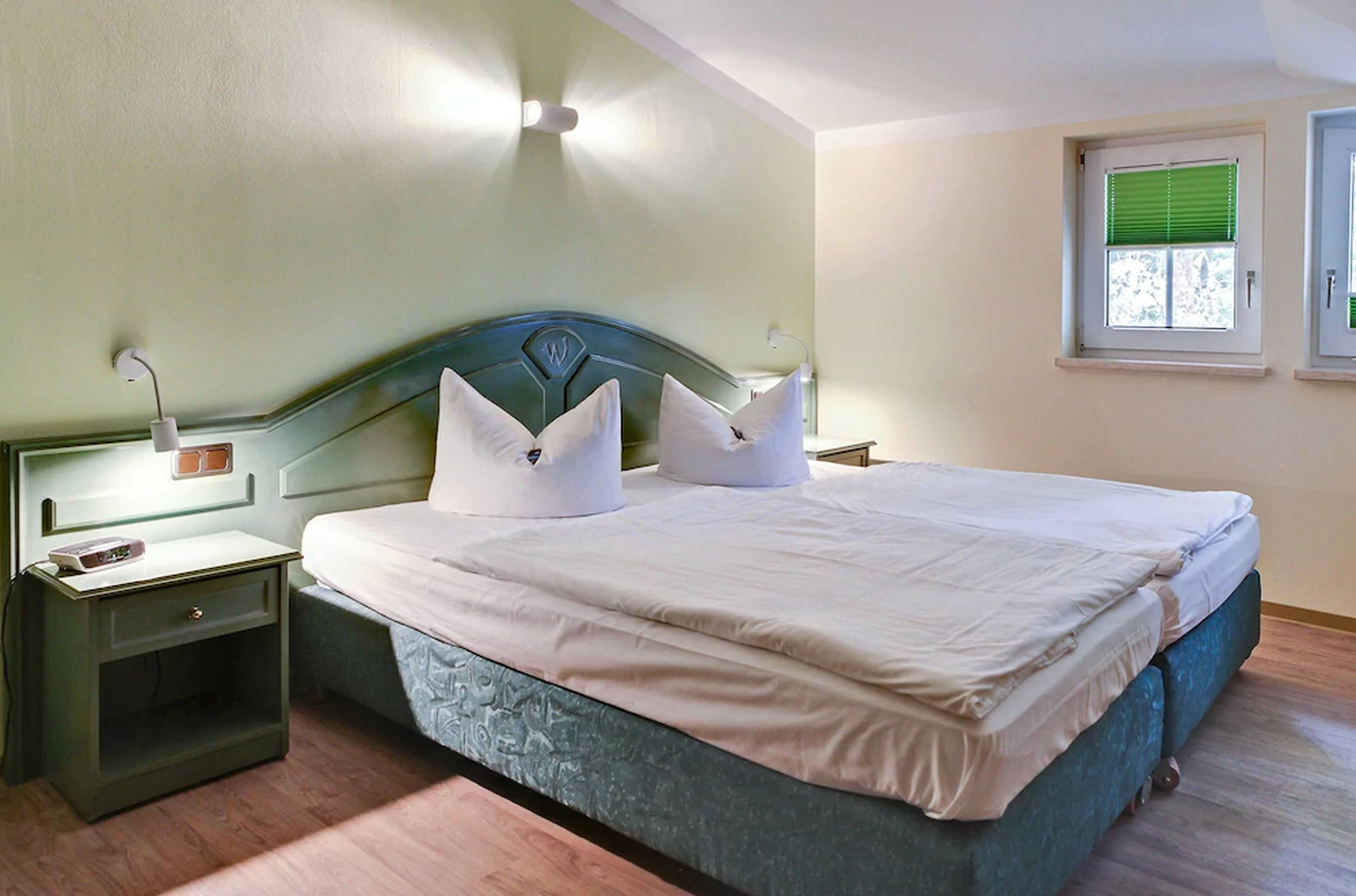 A bedroom with a bed, nightstands, and a window.
