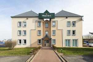 Un bâtiment à deux étages, avec une enseigne indiquant « Mister Bed » à l’entrée.