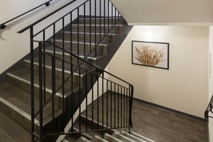 Un escalier avec des rampes noires et des marches en bois.