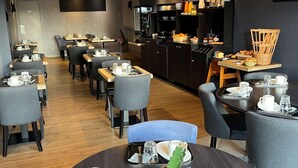 A modern dining area with round tables, grey upholstered chairs, and a central kitchen area with a buffet. - Hotel le Broceliande, Sure Hotel Collection by Best Western (Bedee)
