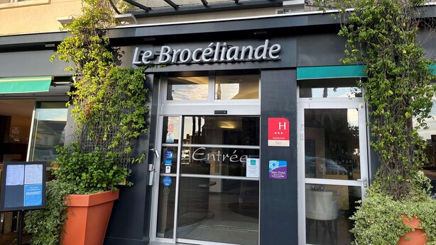 The exterior of Le Brocéliande hotel with a glass entrance, a sign indicating it is a 4-star hotel, and a Sure Hotel logo. - Hotel le Broceliande, Sure Hotel Collection by Best Western (Bedee)