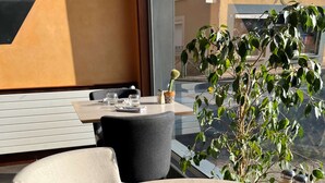 A clean, modern outdoor dining area with round tables, chairs, and clear glassware. - Hotel le Broceliande, Sure Hotel Collection by Best Western (Bedee)