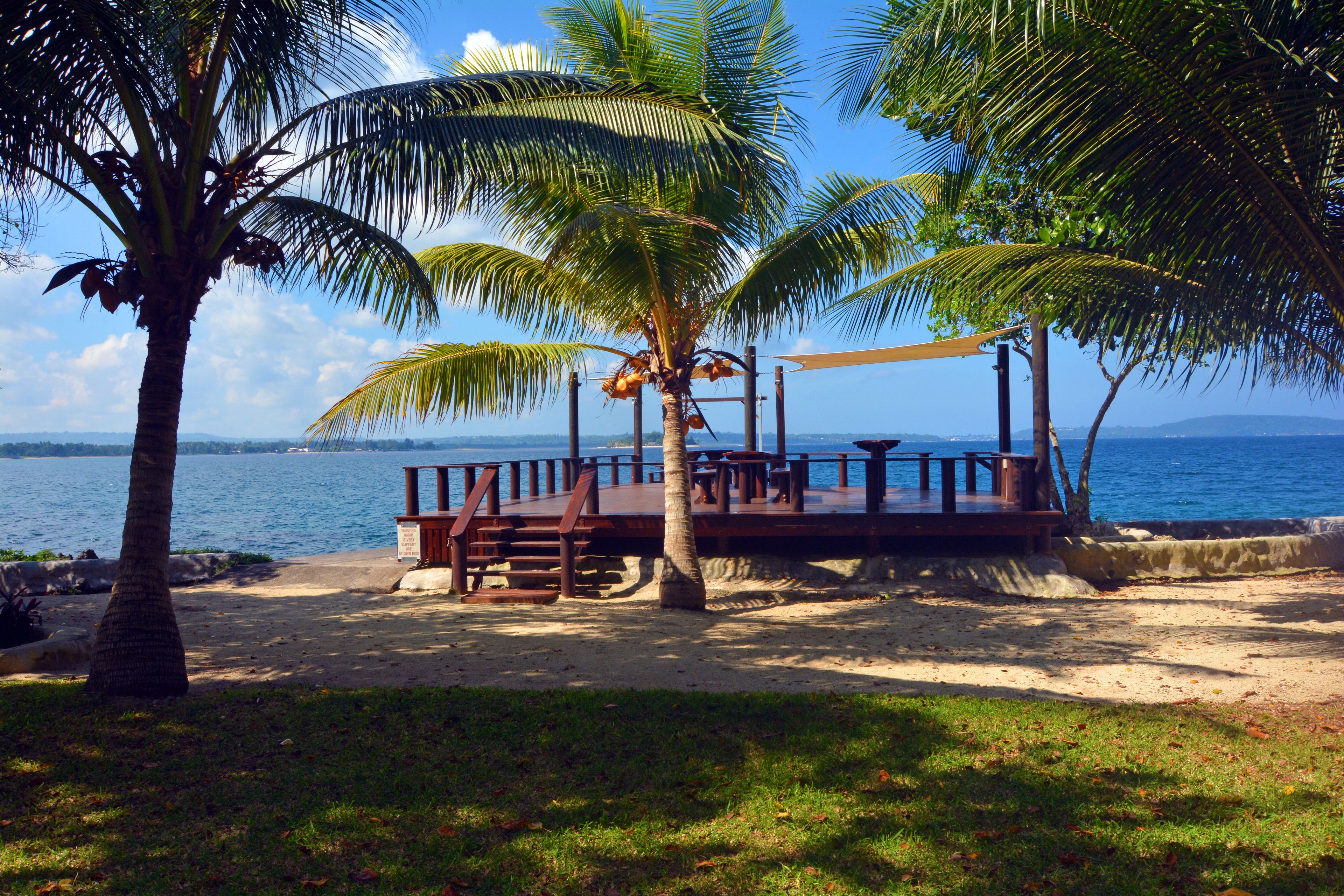 على الشاطئ، رمال سوداء، كراسي للتشمس، مظلات الشاطئ