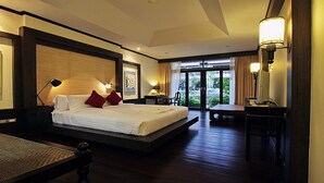 A hotel room with a large bed, bedside tables, a desk, and a view of the outdoors.