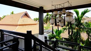 A covered outdoor area with a wooden ceiling, black railings, and hanging lanterns.
