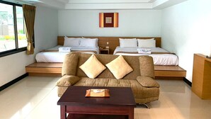 Une chambre d’hôtel avec deux lits, un canapé, un plafond en bois et une fenêtre avec des rideaux.