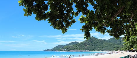 Am Strand, weißer Sandstrand, Sonnenschirme, Strandtücher