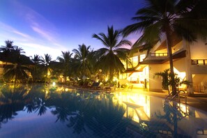 Una piscina al aire libre, sombrillas, sillones reclinables de piscina