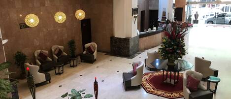 A hotel lobby with seating areas, a reception desk, and a Christmas tree.