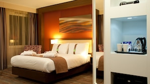 A hotel room with a large bed, a bedside table with a lamp, and a tray with cups and a coffee maker. - Holiday Inn Derby Riverlights by IHG (Derby)