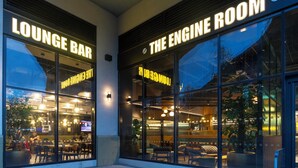 A lounge bar and an engine room with large windows, seating, and indoor plants. - Holiday Inn Derby Riverlights by IHG (Derby)