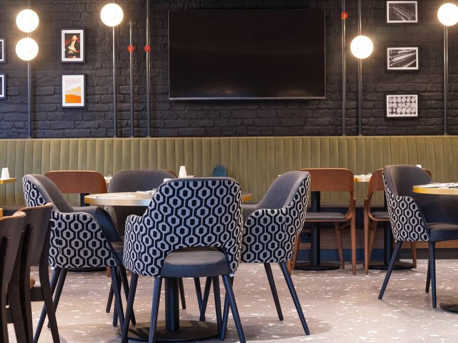 A restaurant with a dark brick wall, framed pictures, and modern lighting.