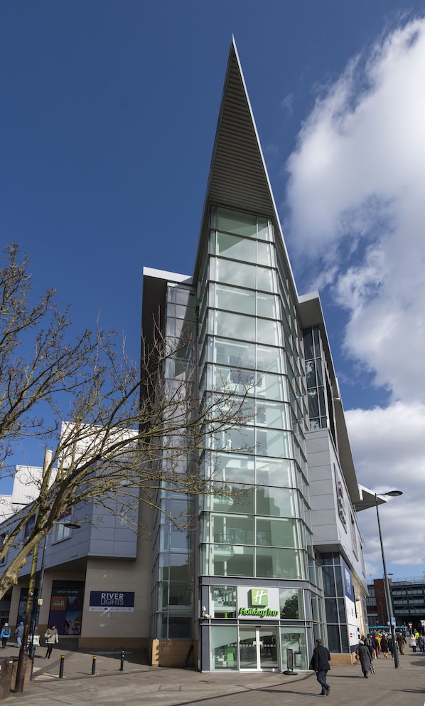 A modern building with a glass facade and a prominent triangular roof.
