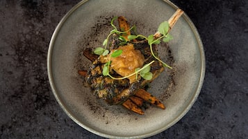 Un plato con salsa verde, decorado con microbrotes.