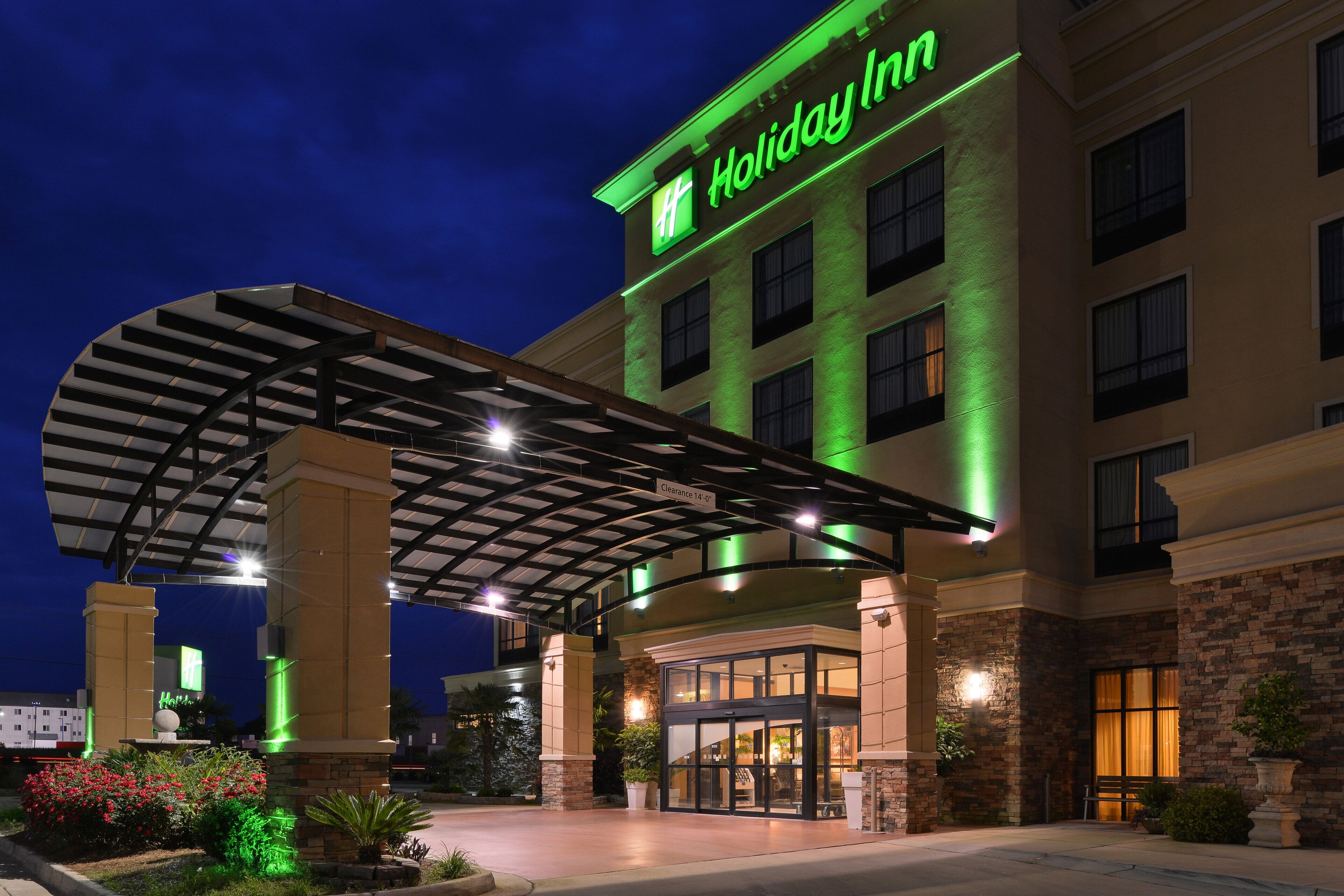 A Holiday Inn hotel with a covered entrance, multiple floors, and a well-lit facade.