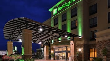 A Holiday Inn hotel with a covered entrance, multiple floors, and a well-lit facade.