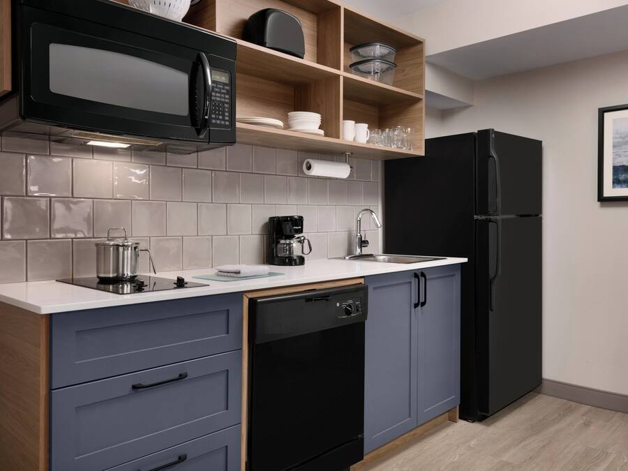 Una cucina moderna dotata di forno a microonde, macchina del caffè e lavastoviglie.