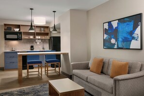 A modern living space with a kitchen, a dining area, and a sofa. - Candlewood Suites Fayetteville Fort Bragg by IHG (Fayetteville)