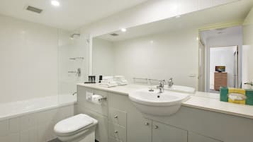 Une salle de bain moderne avec une baignoire, des toilettes, un lavabo et un grand miroir.