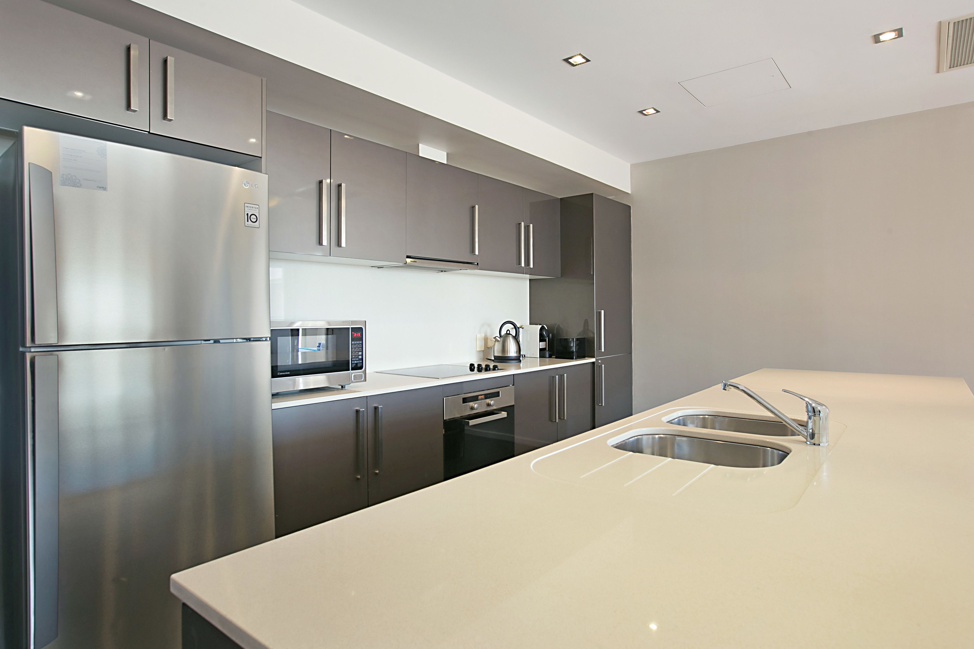 A modern kitchen with stainless steel appliances, a microwave, and a sink.