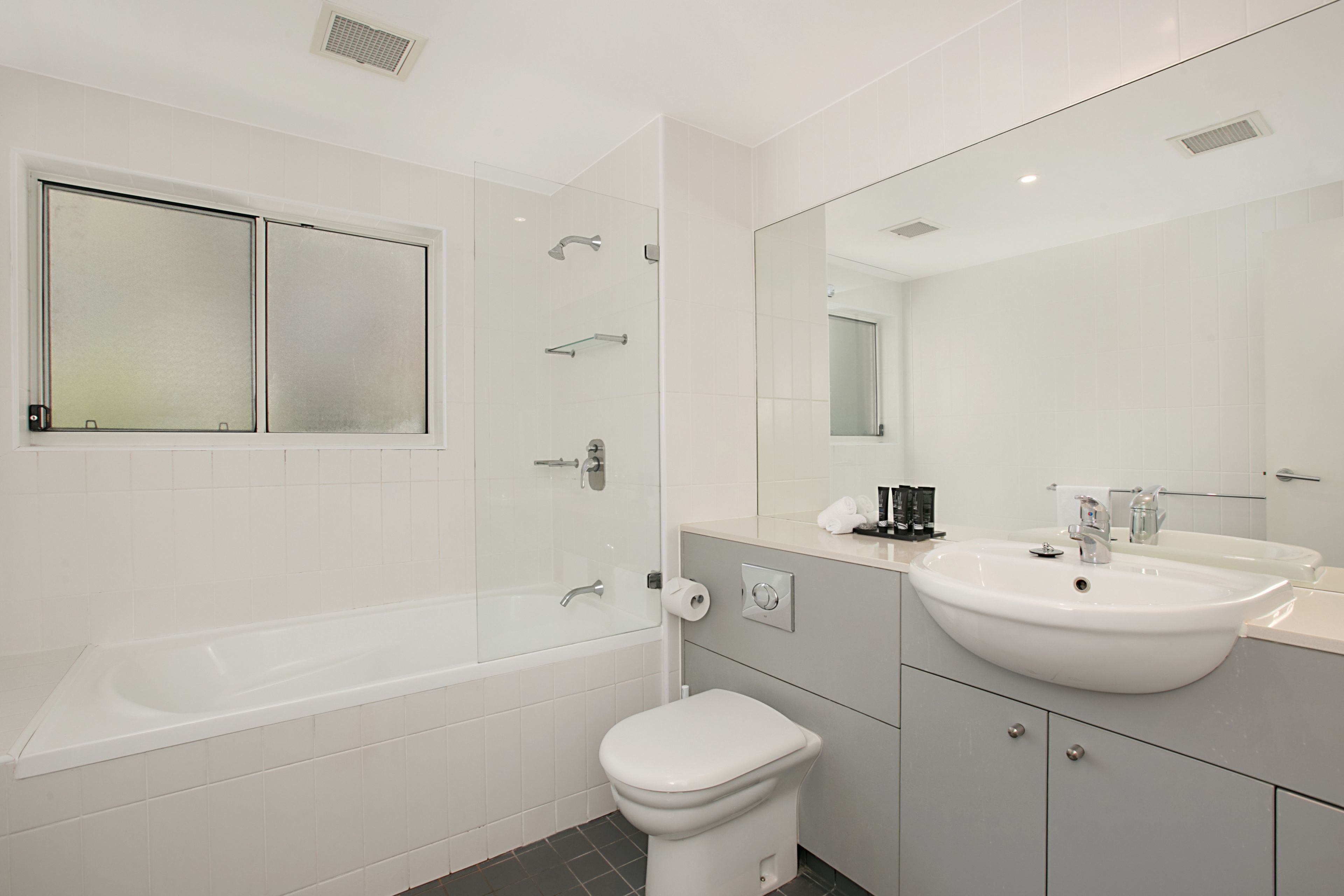 A modern bathroom with a bathtub, toilet, and sink.