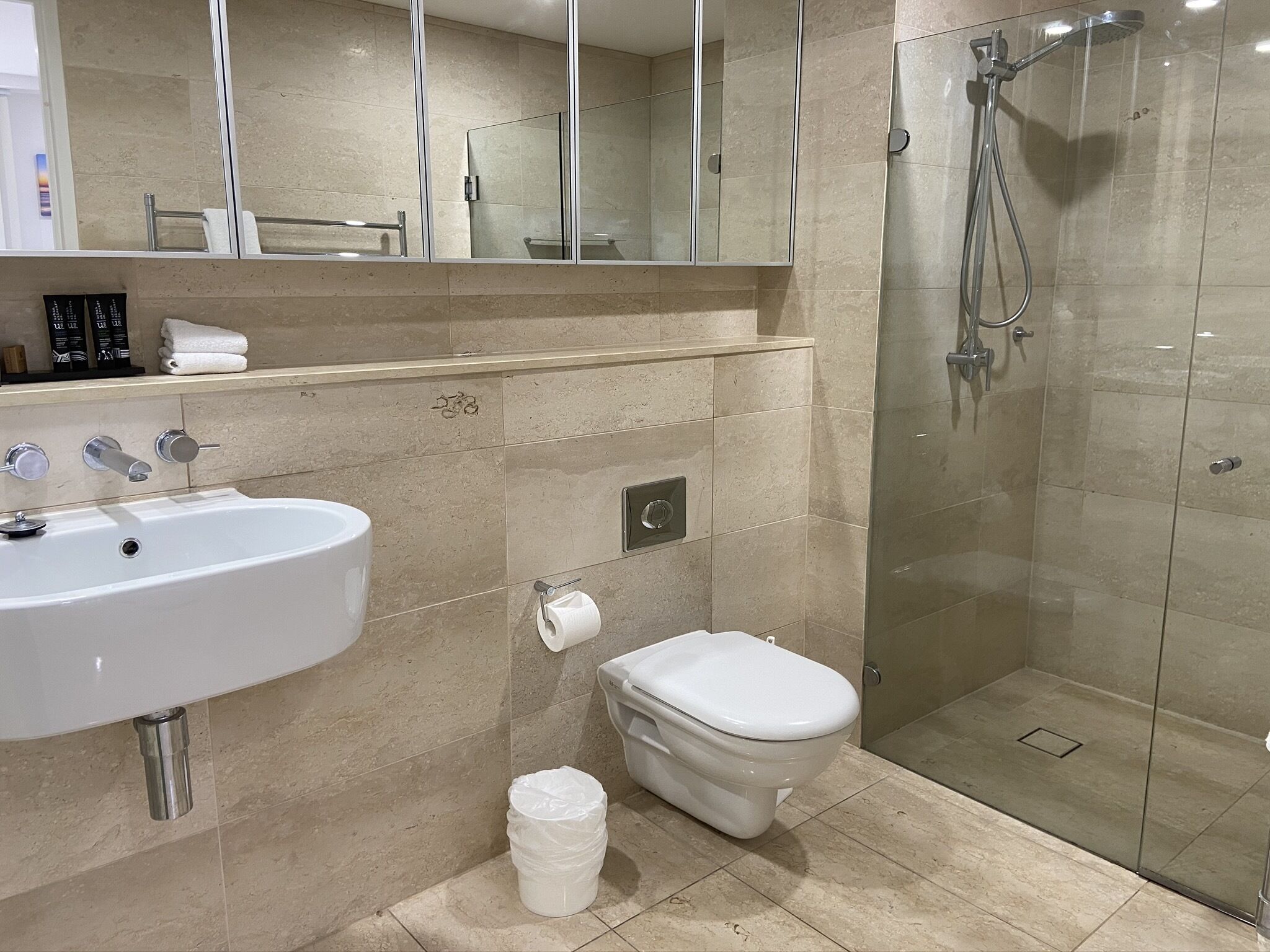 A modern bathroom with a sink, toilet, and glass-enclosed shower.