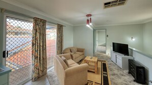 A living room with a sofa, TV, and a small table.