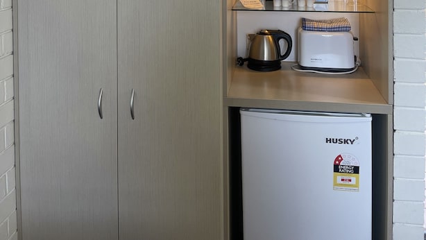 Une petite cuisine équipée d’un four à micro-ondes, d’une machine à café et d’un réfrigérateur.
