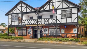 A traditional half-timbered building with a covered front area, multiple windows, and outdoor seating.