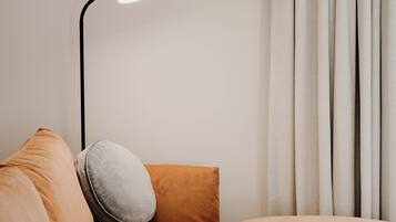 A modern living room with a sofa, a round wooden coffee table, and a floor lamp.