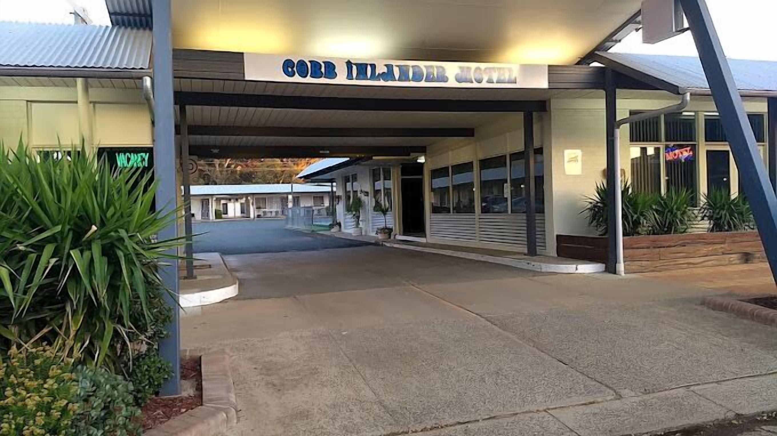 The entrance to the Gorey Island Hotel with a covered walkway and potted plants.