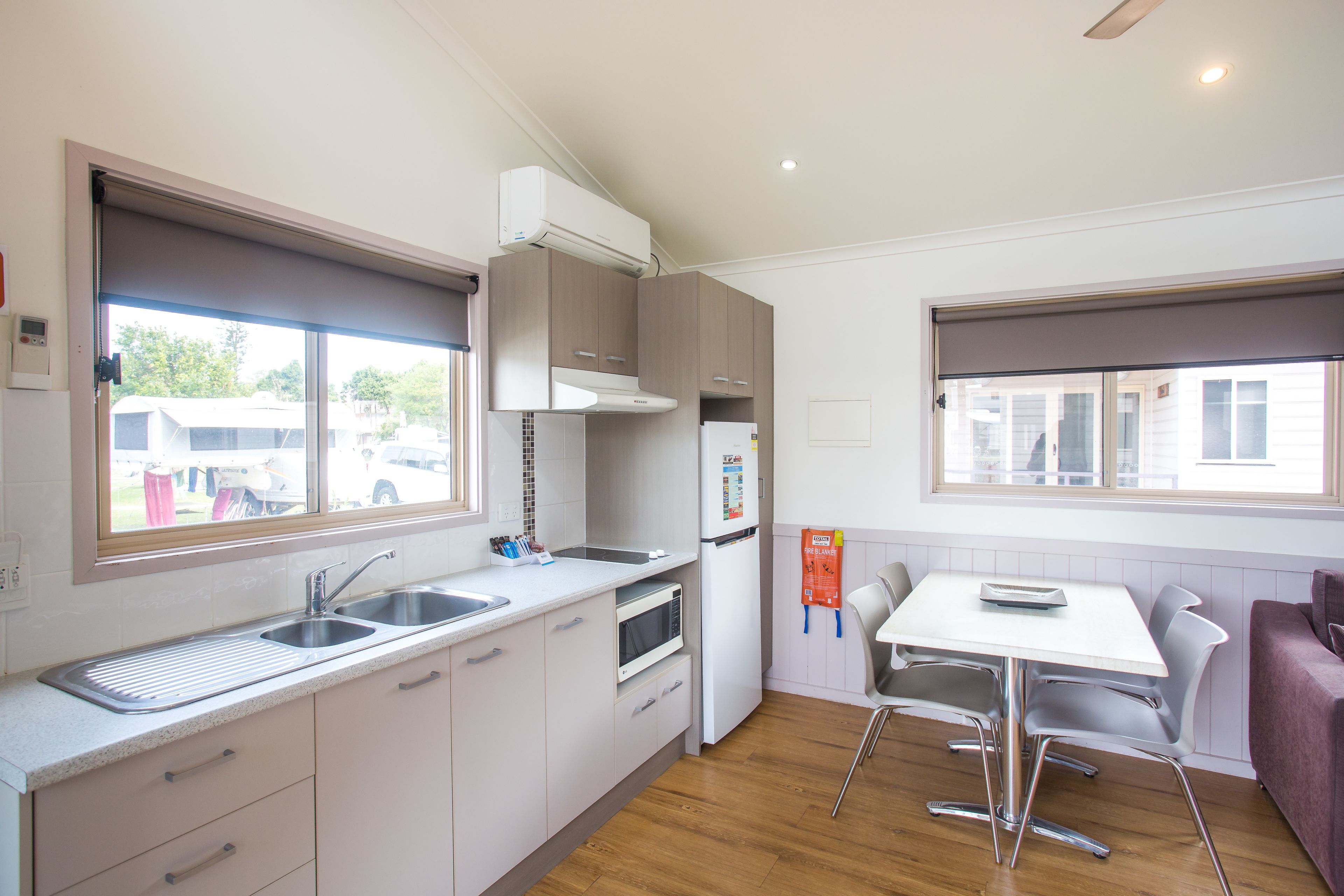 A modern kitchen with a built-in oven, a refrigerator, and a window with a view of the outside.