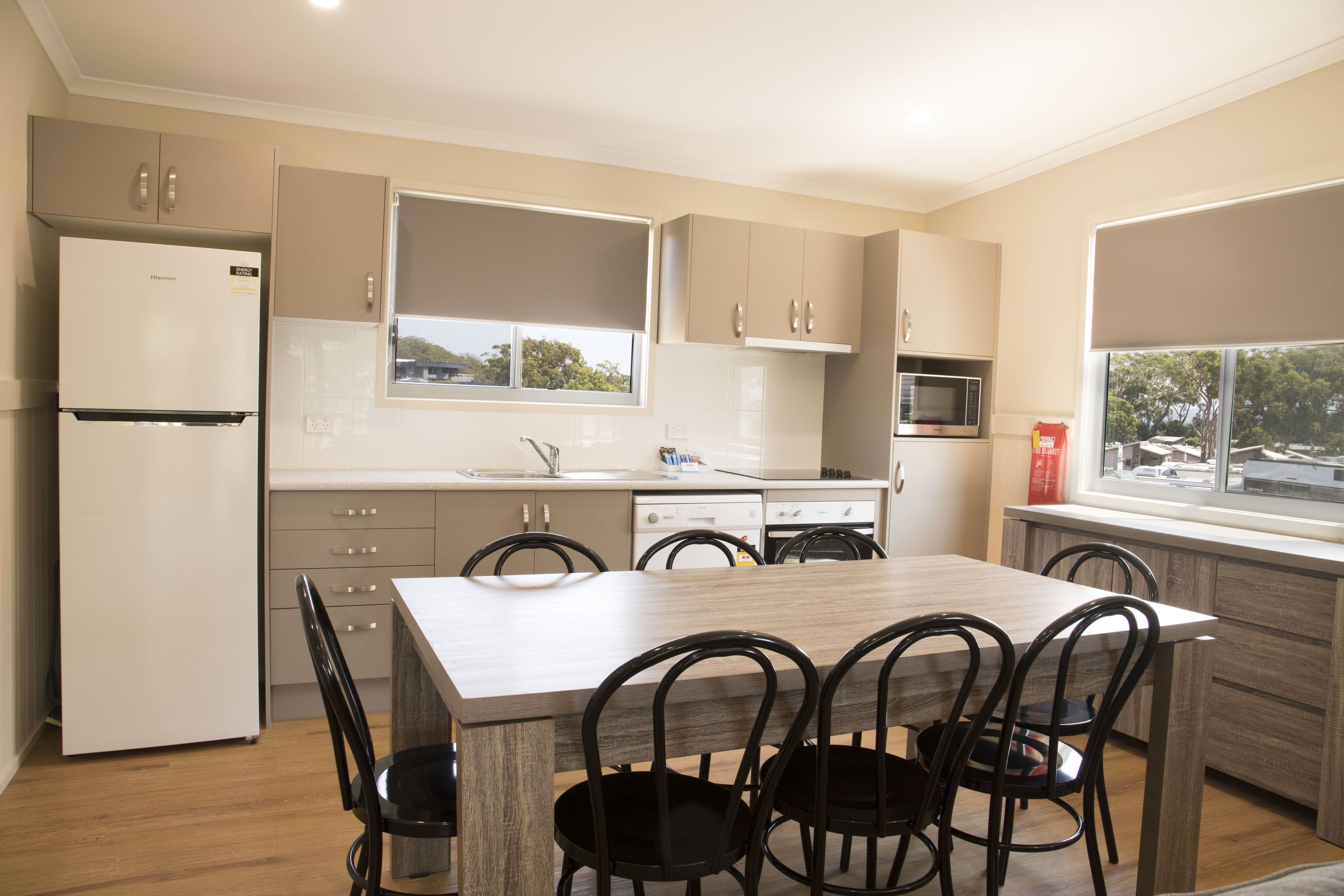 Cocina moderna con comedor, que incluye refrigerador, microondas, pileta y alacenas.