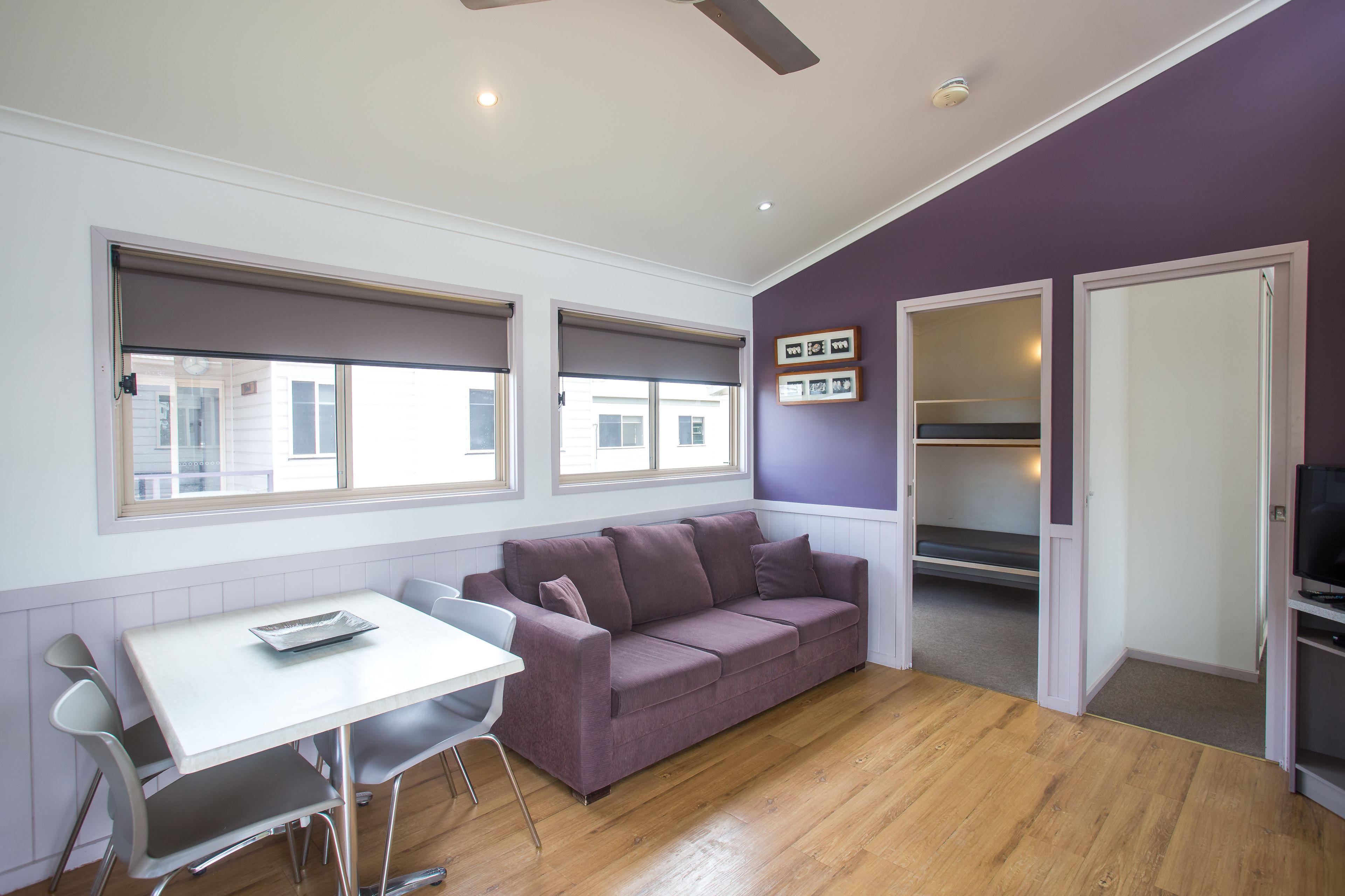 A compact living space with a sofa, a dining table, and a TV.