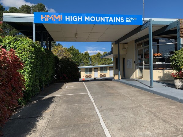 A motel named "High Mountains Motor Inn" with a covered parking area and a small building with a signboard. - High Mountains Motor Inn (Blackheath)