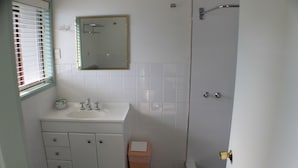 Ein Badezimmer mit Waschbecken, Spiegel und gefliesten Wänden.