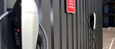 Una estación de carga para vehículos Tesla, con un cartel que indica que es para la carga de vehículos Tesla.