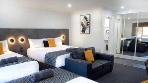 A hotel room with two beds, a sofa, and a large mirror. - Orana Motel Dubbo (Dubbo)