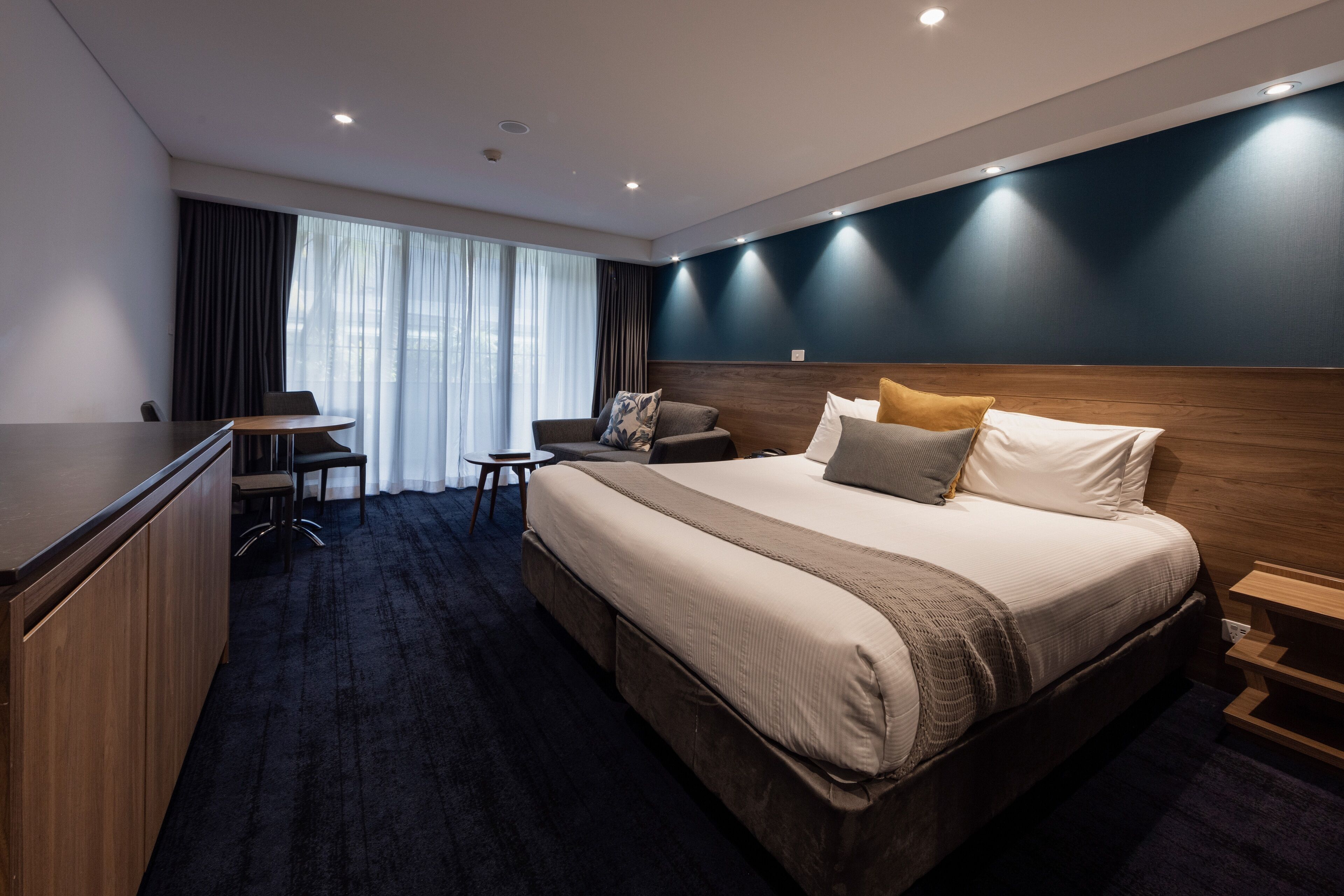 Une chambre d’hôtel avec un grand lit, un bureau et une chaise.