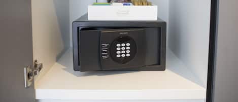 A minibar with a secure lock, a bottle of wine, a pack of cigarettes, and a box of tissues.