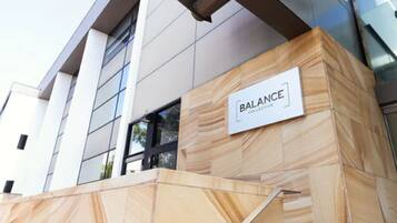 Experience the sleek, contemporary design of Balance Collective's building facade, featuring large windows and a clean geometric style.