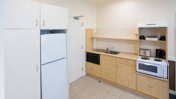 Eine kleine Küche mit Kühlschrank, Mikrowelle, Toaster und Spüle.