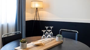 Una mesa de comedor con una tabla de madera, cristalería y plantas en macetas.