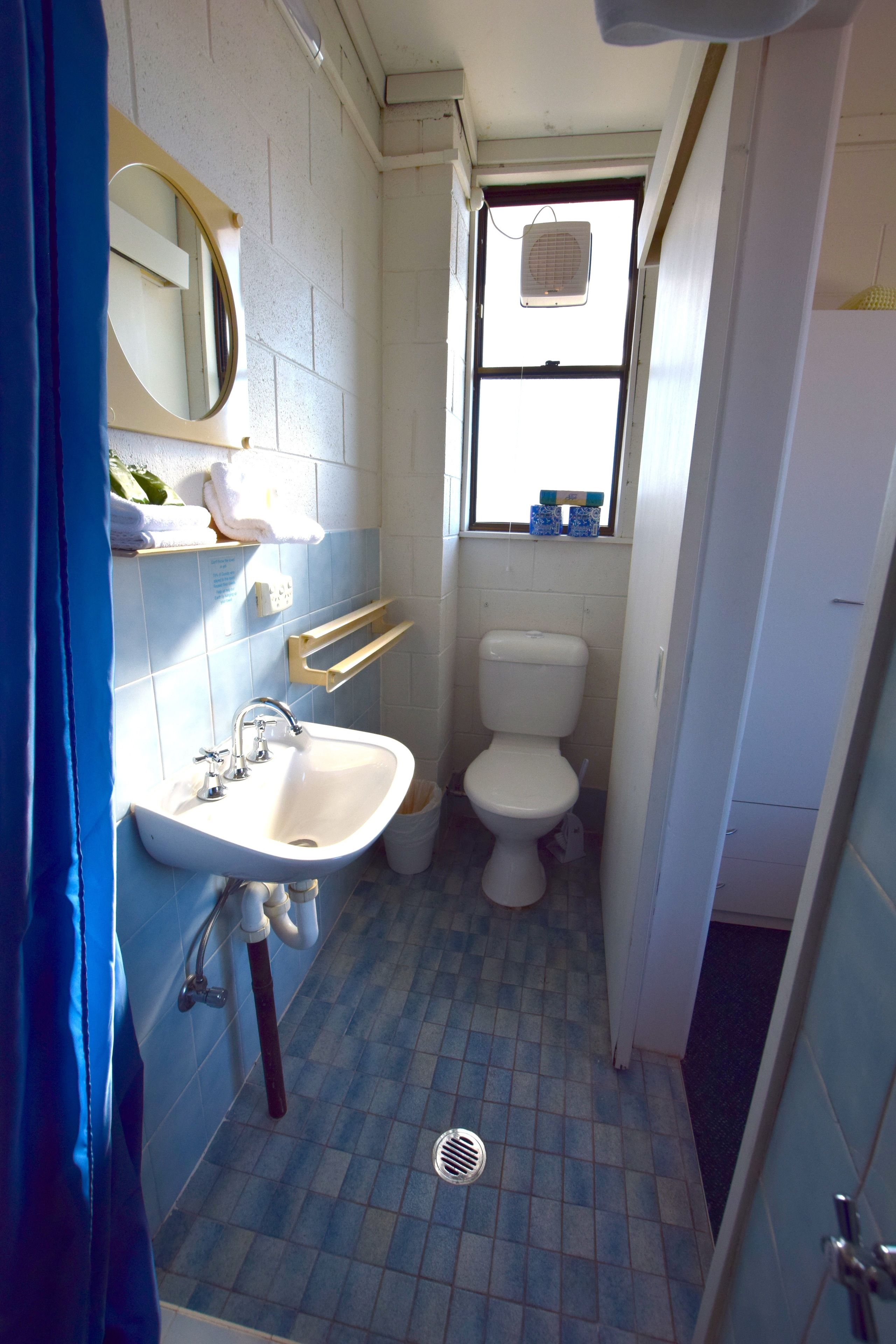Un baño pequeño con lavamanos, espejo e inodoro.