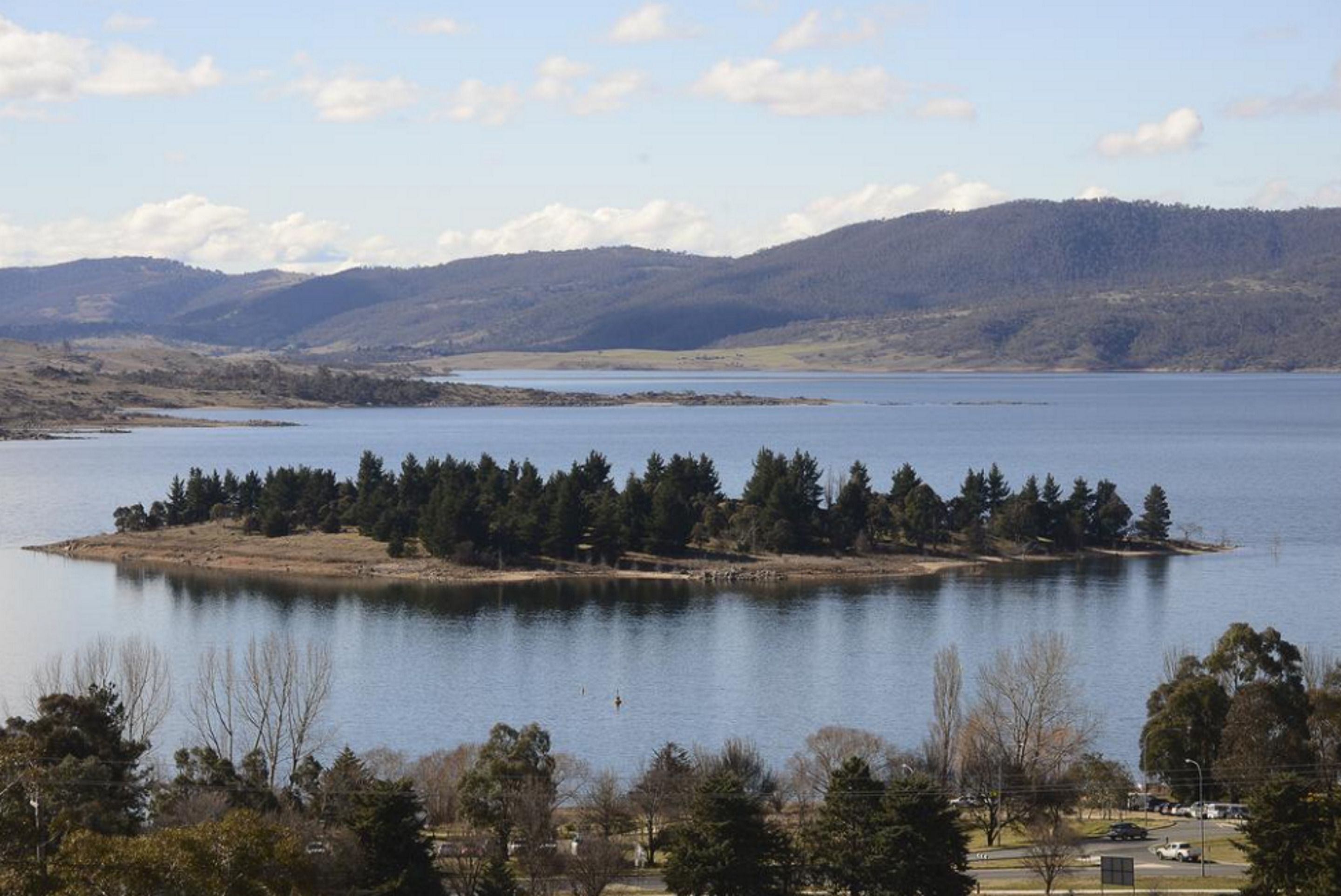 A lake surrounded by hills and trees.