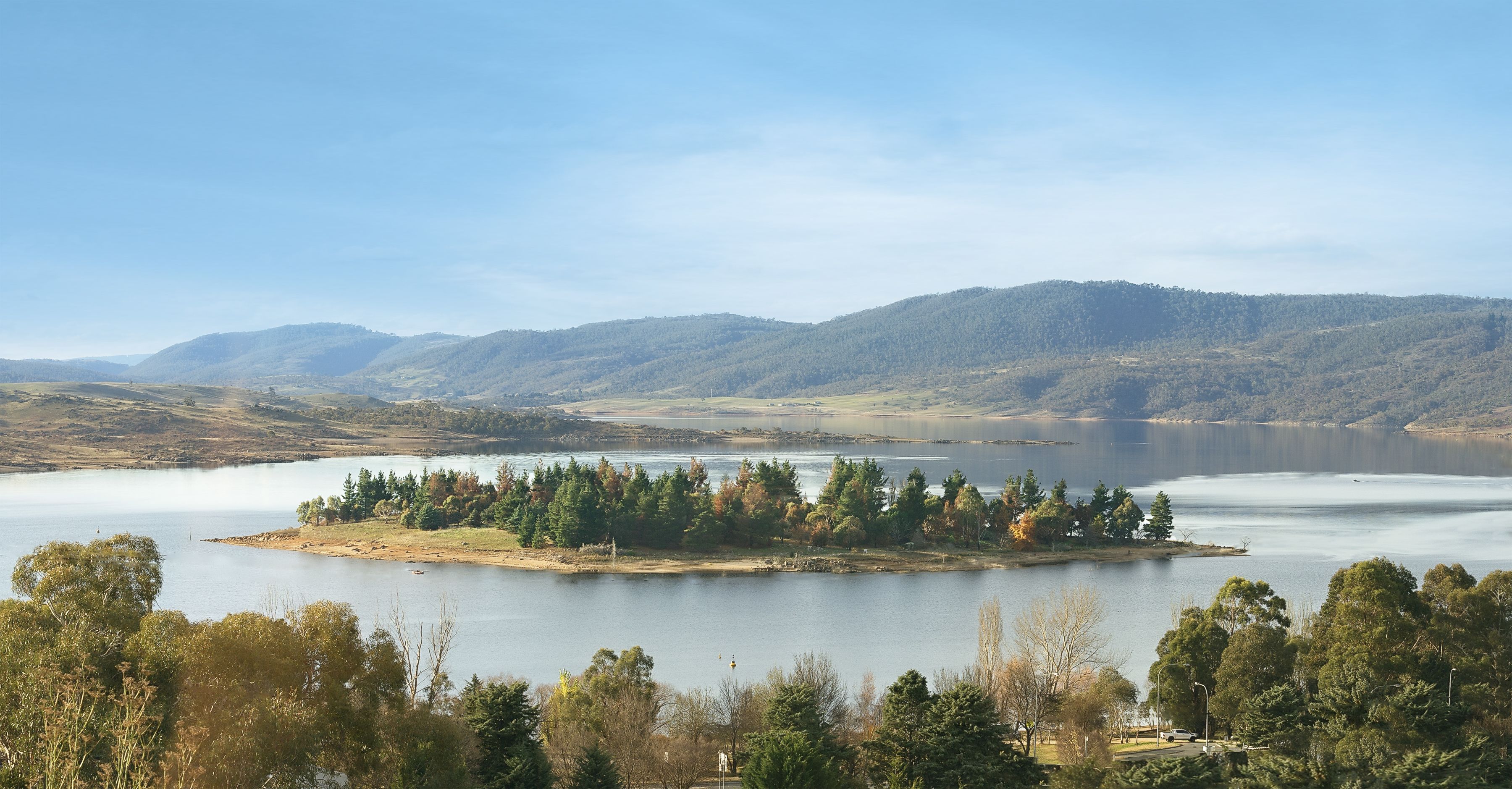 Un lago rodeado de colinas y árboles.