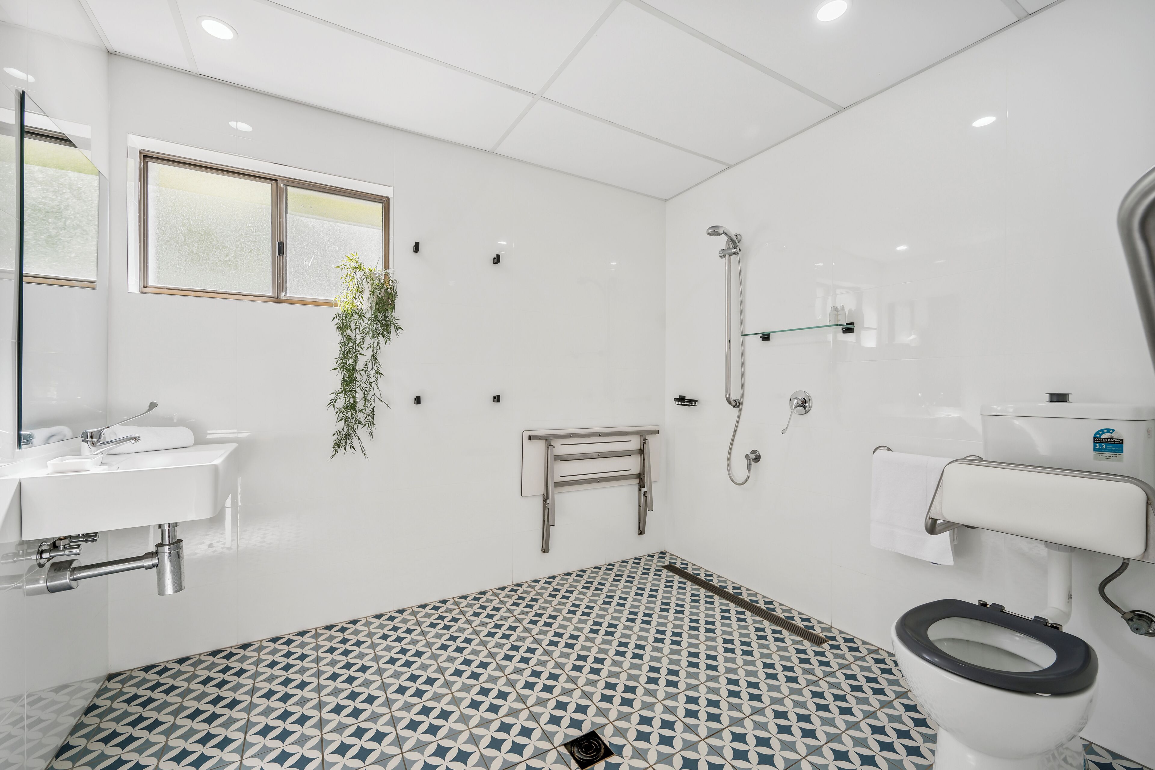 A bathroom with a toilet, bidet, sink, and shower.