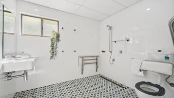 Un baño con inodoro, bidé, lavamanos y ducha.