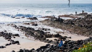A rocky beach with waves crashing onto the shore.
