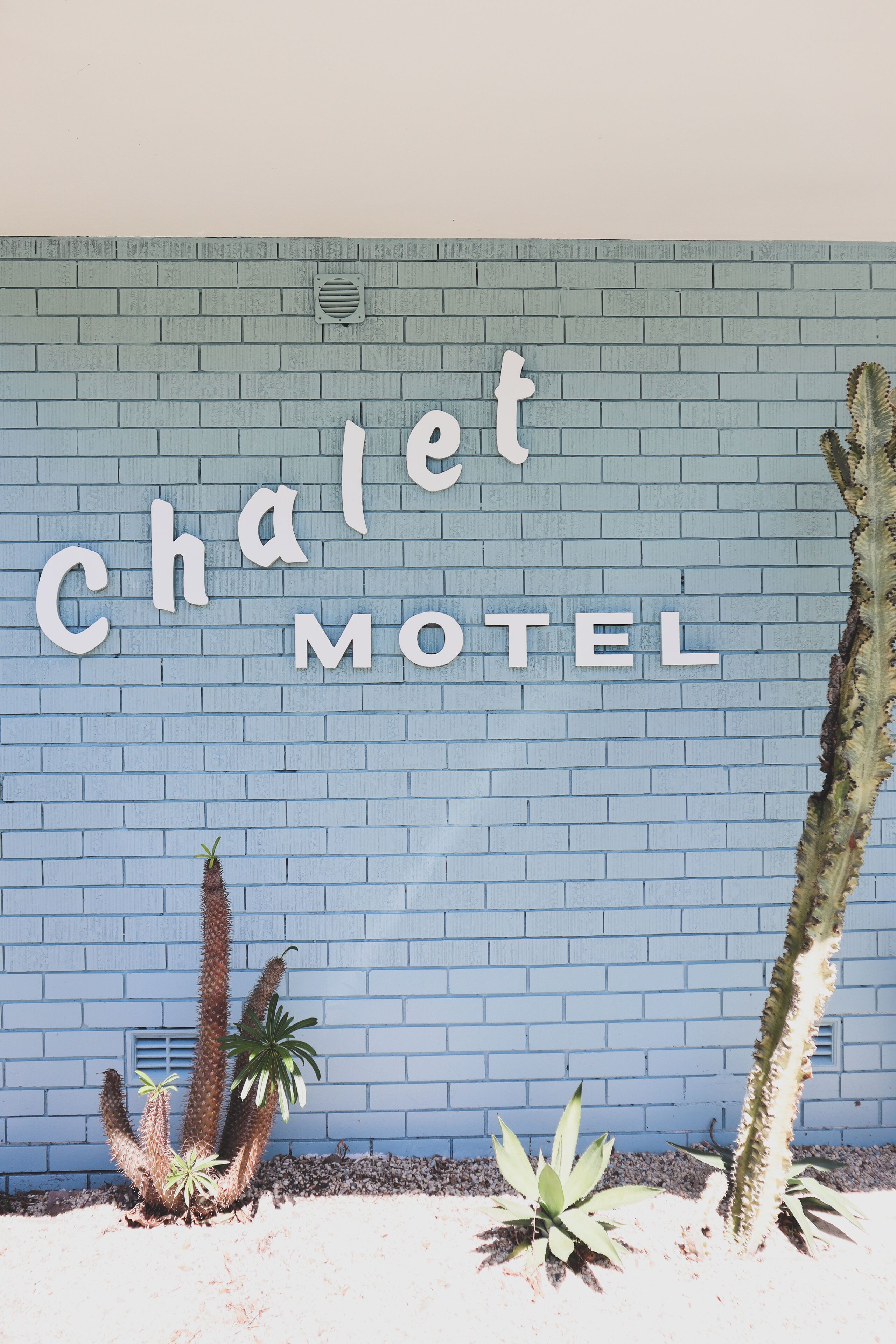 A wall with the words "Chalet Motel" in large letters.
